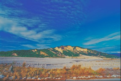 火炎山自然保留區藍天白雲襯托著橘黃礫石山峰。