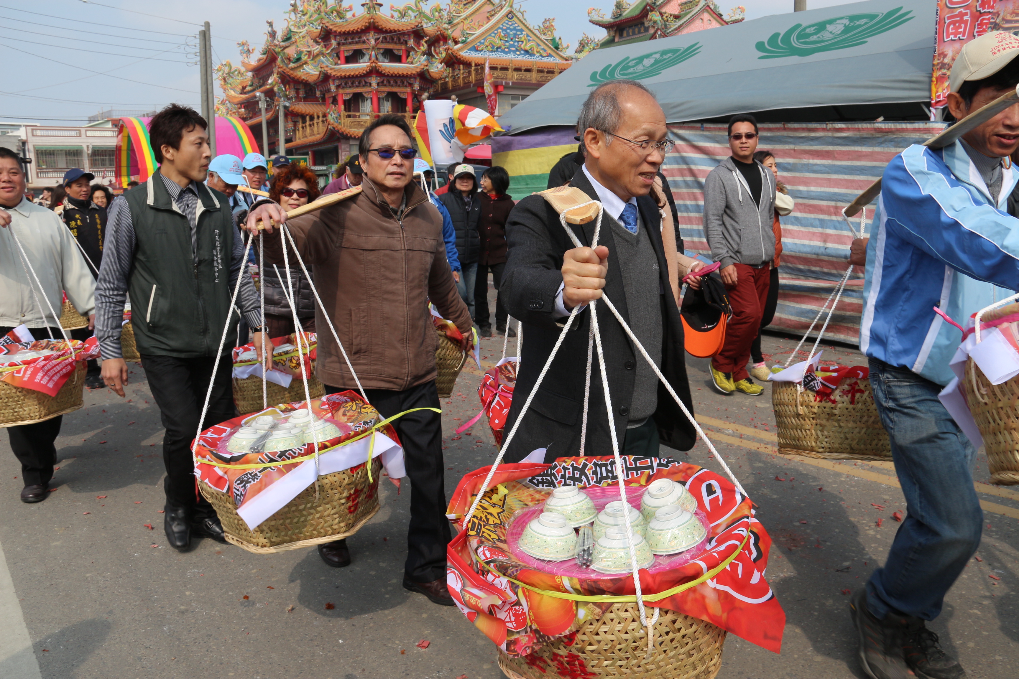 左起行政院雲嘉南聯合服務中心副執行長詹澈、行政院林政則政委兼主席親挑米籃隊伍前行